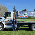 Justin standing in front of a Just-in Time Septic pump truck